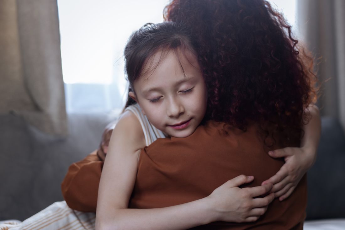 A mother and daughter holding each other in a tender embrace