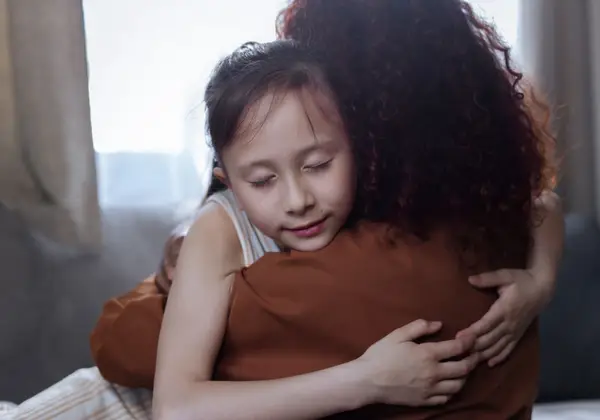 A mother and daughter holding each other in a tender embrace