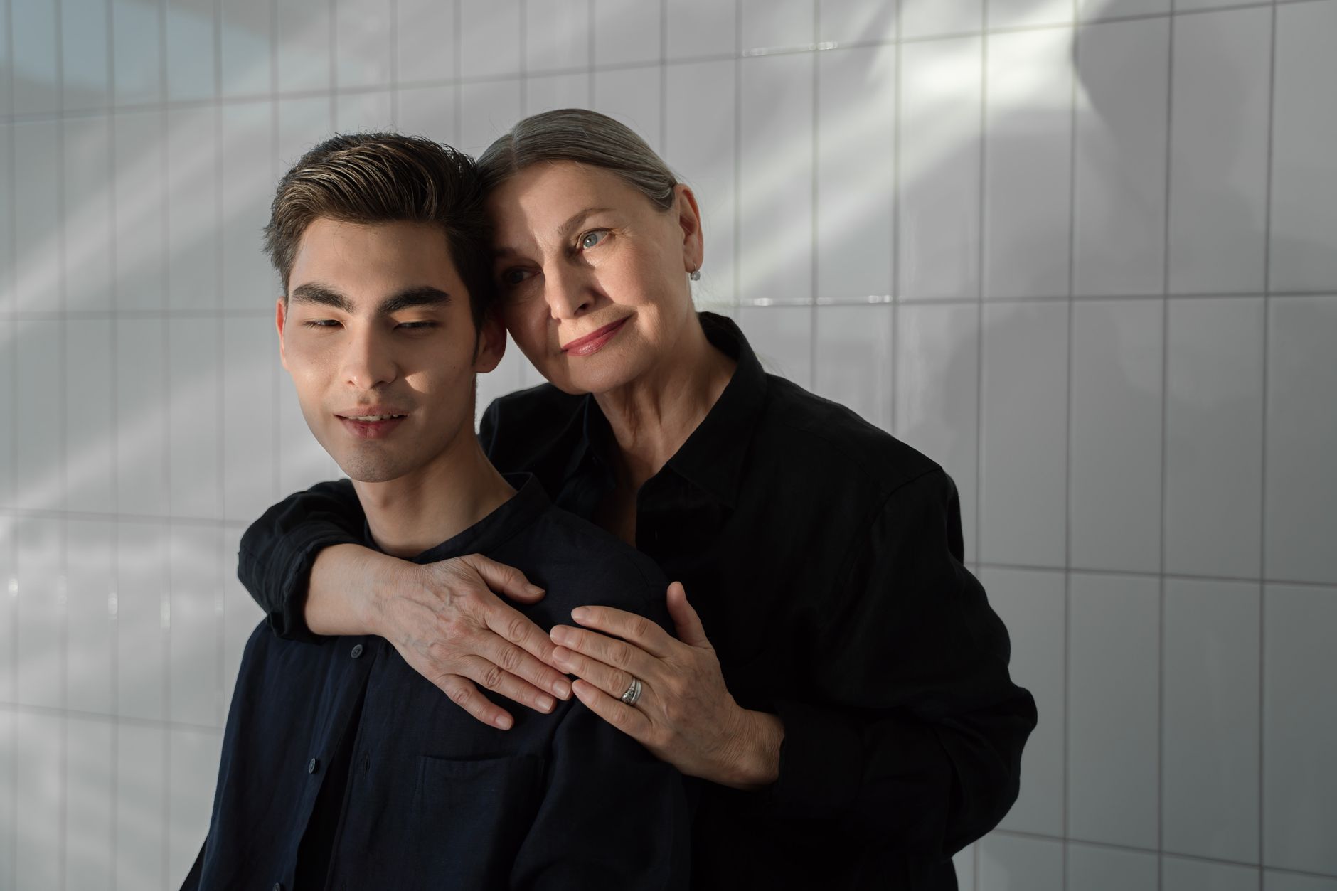 An older woman embracing her grown son tenderly