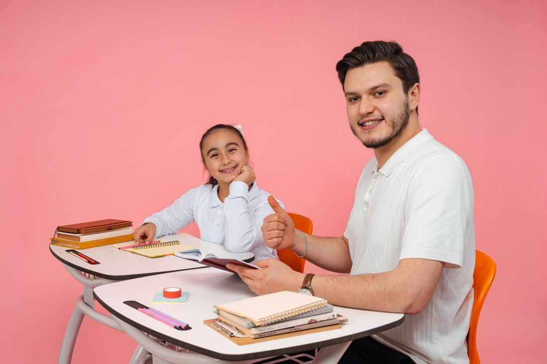A teacher smiling warmly at the front of her classroom