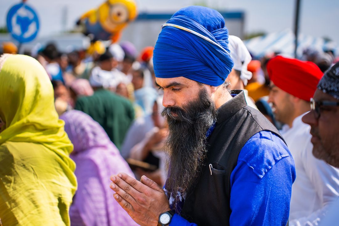 A man with hands together in prayer at a gathering