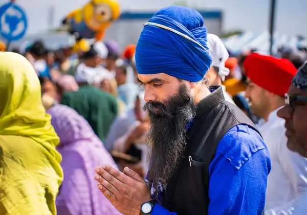 A man with hands together in prayer at a gathering