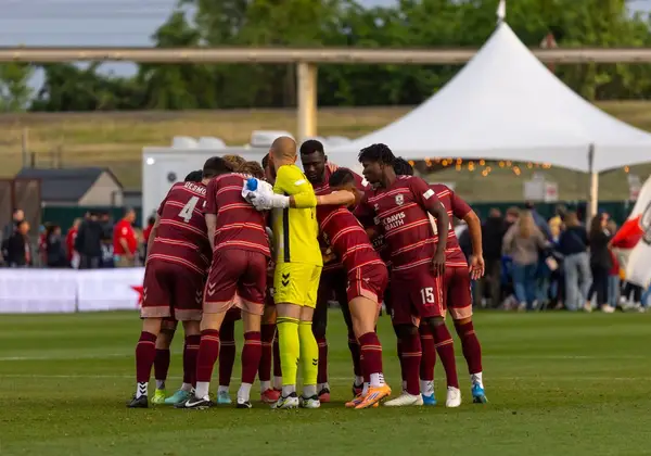 A diverse team in a pre-game huddle on the pitch