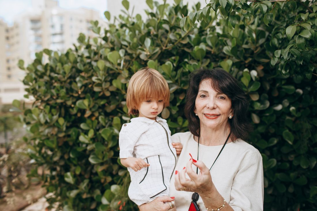 A grandmother holding her young grandchild outdoors