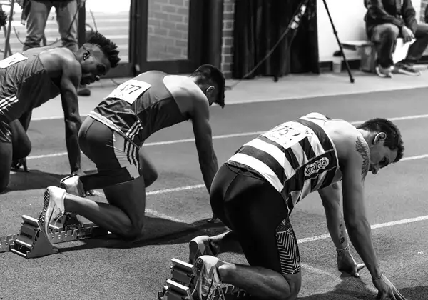 Sprinters set in the starting blocks, focused