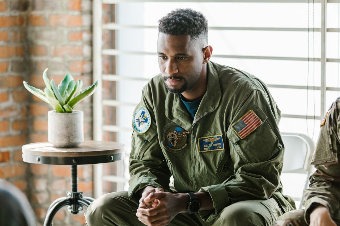 A veteran sitting with hands clasped in a quiet moment