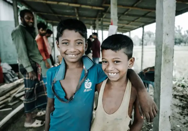 Two Bangladeshi boys smiling together in a village