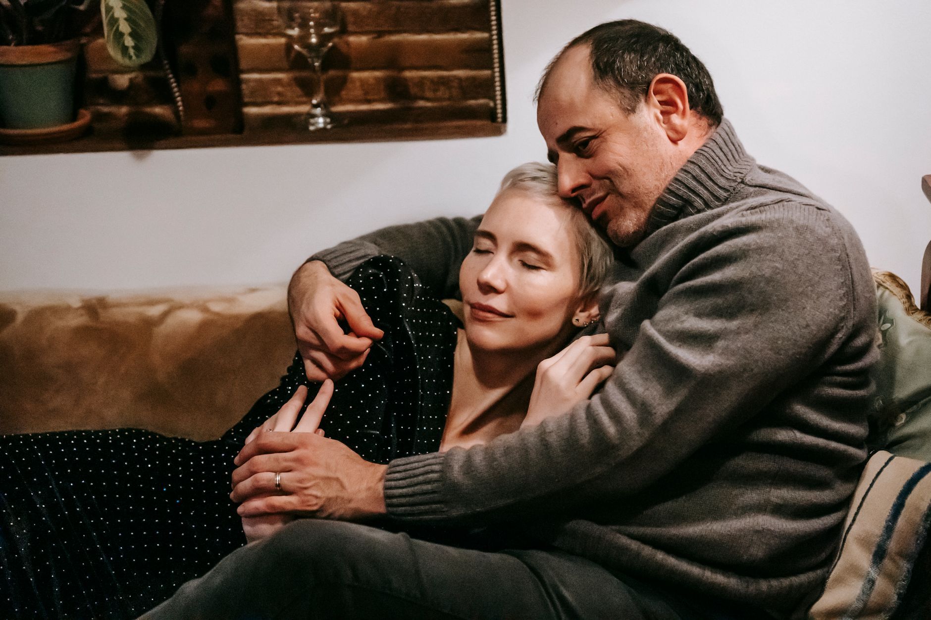 A couple resting in a tender embrace at home