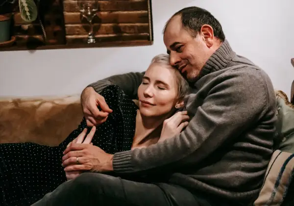 A couple resting in a tender embrace at home