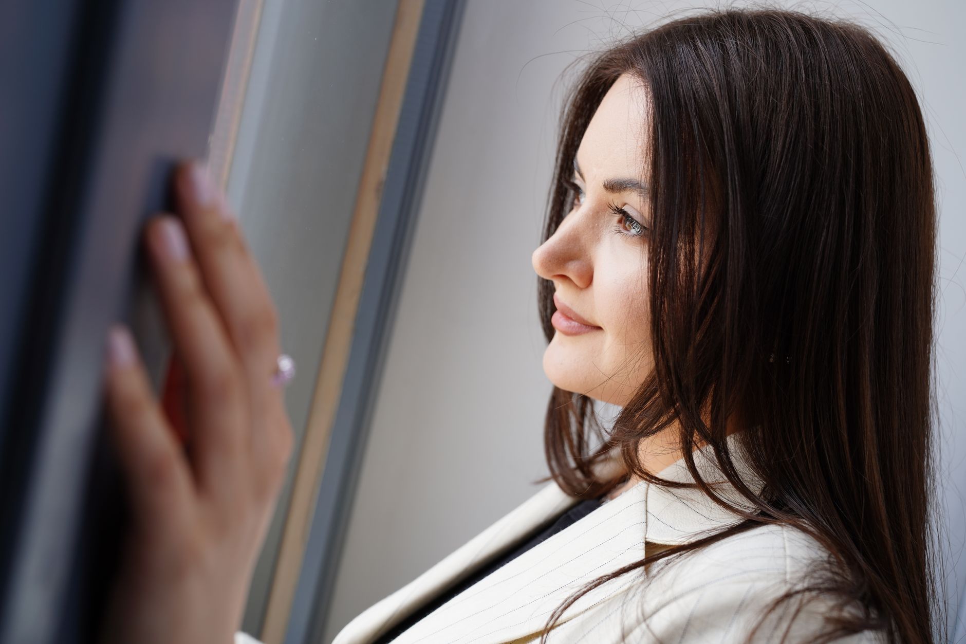 A businesswoman looking out a window in quiet reflection