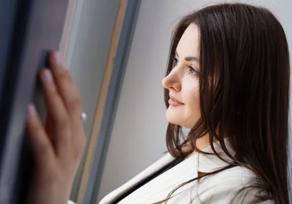 A businesswoman looking out a window in quiet reflection
