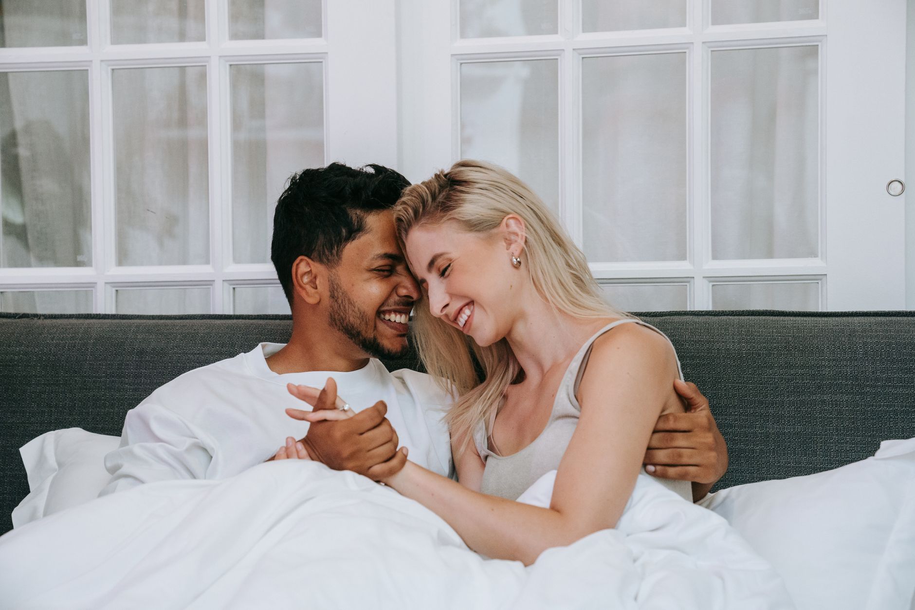 A young couple laughing forehead to forehead