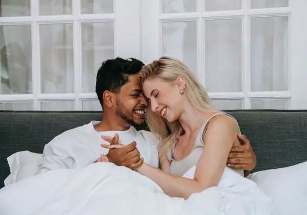 A young couple laughing forehead to forehead