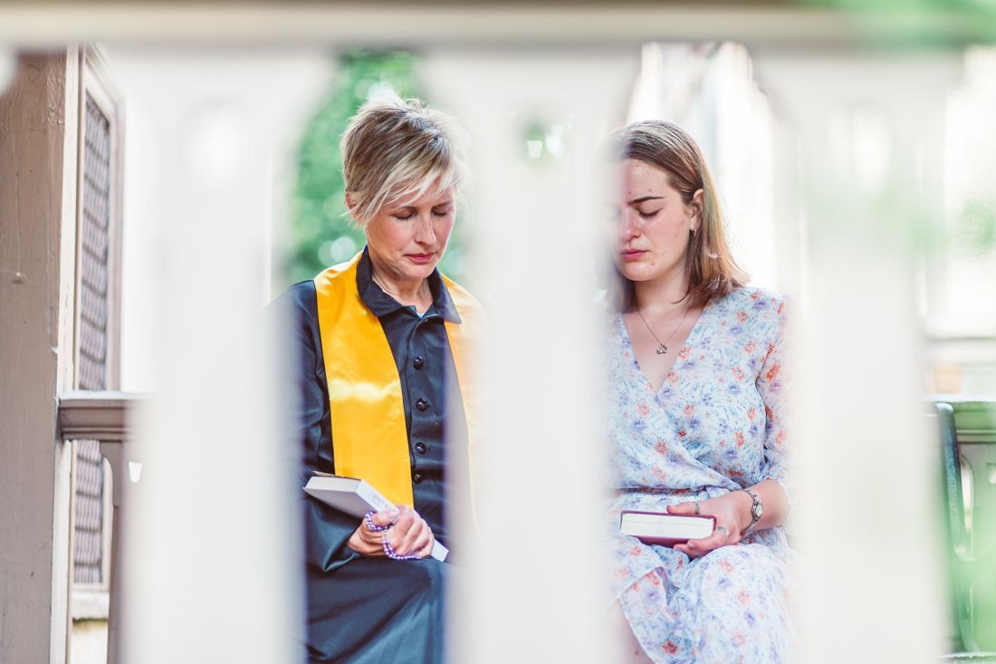 A leader praying with a teenage girl