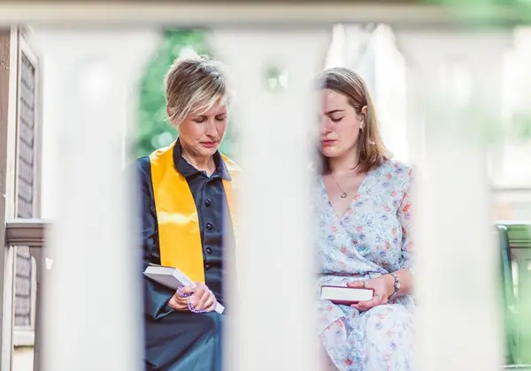 A leader praying with a teenage girl