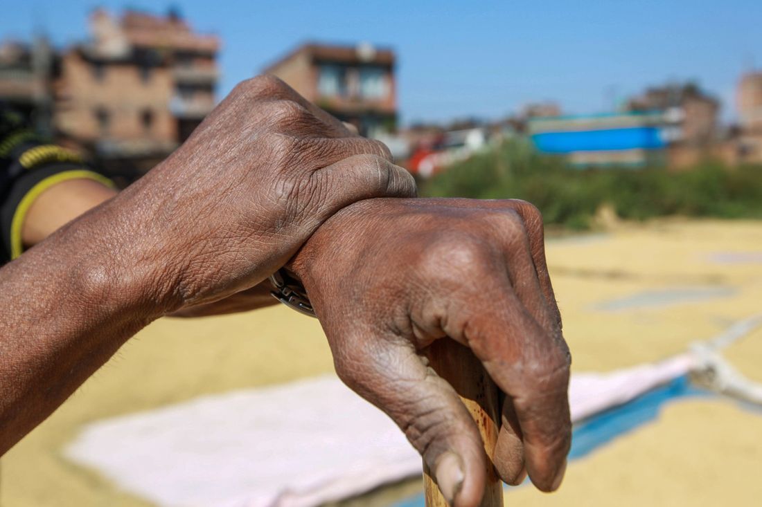 The weathered hands of an older worker at rest