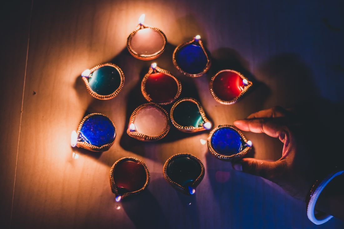 Colorful oil lamps being lit in devotion