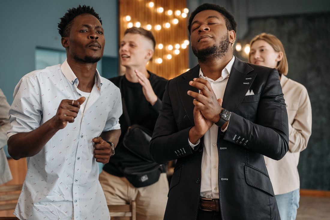 Men worshiping together with hands lifted