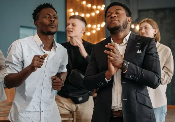 Men worshiping together with hands lifted