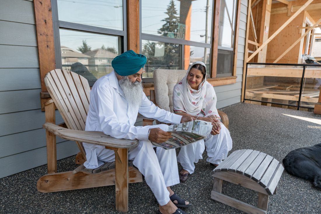 An older couple reading together on the porch