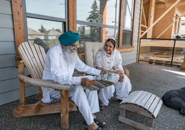 An older couple reading together on the porch
