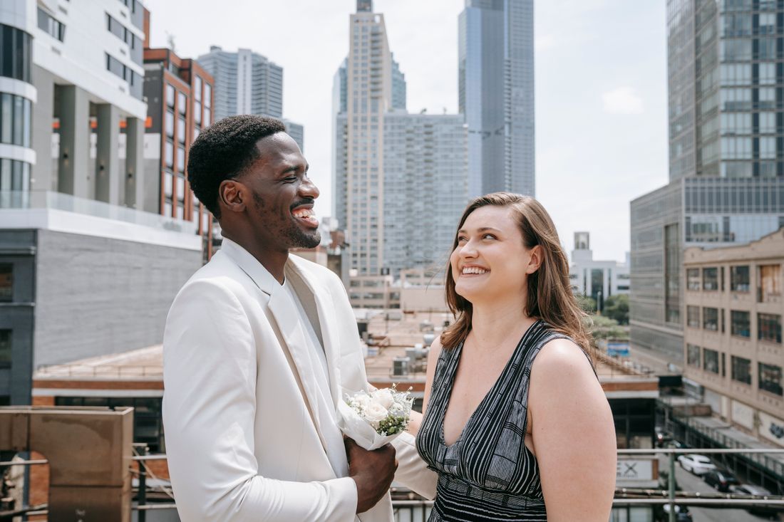 A husband and wife laughing together on a city rooftop