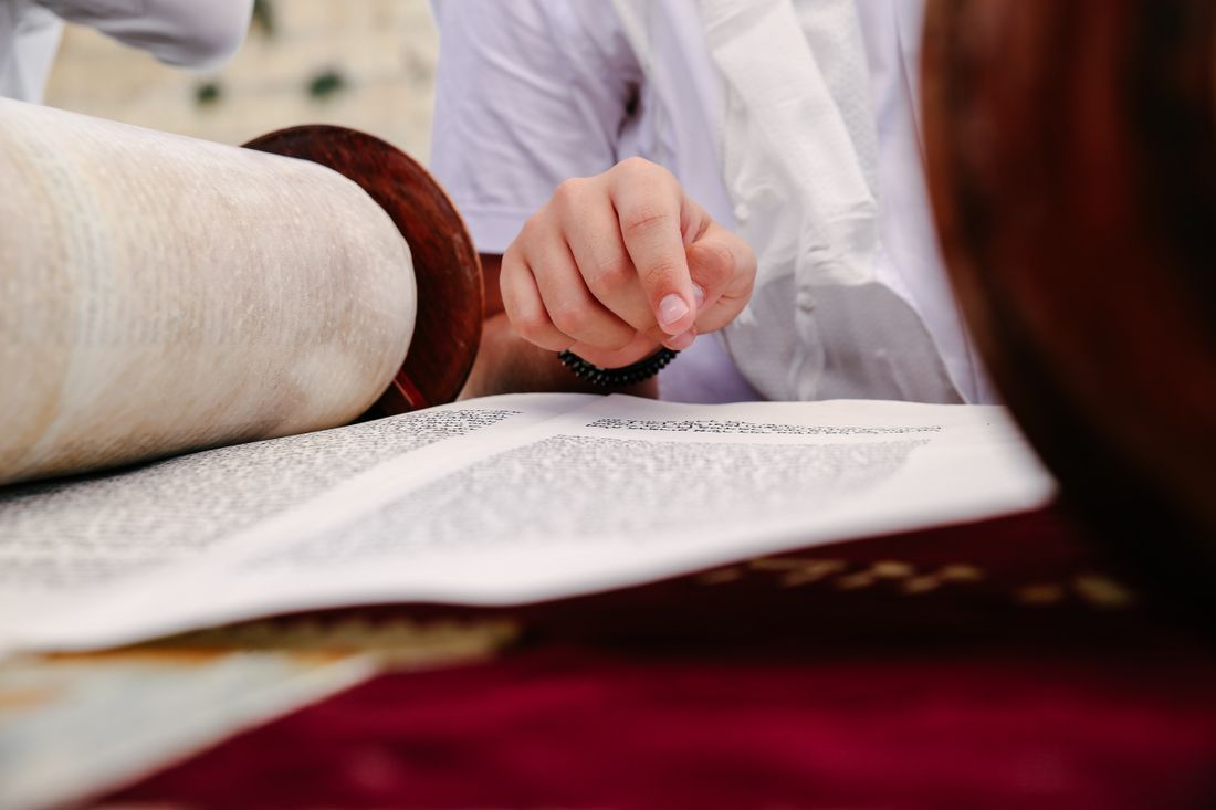 Reading from a Torah scroll with a silver pointer