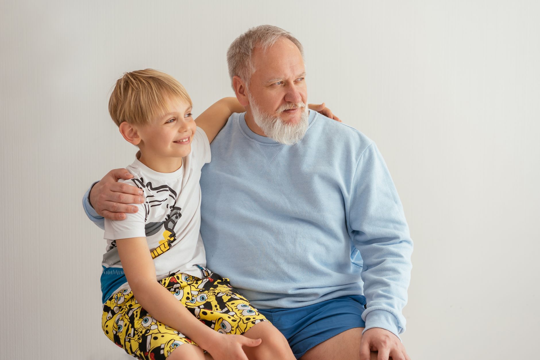 A grandfather with his arm around his young grandson