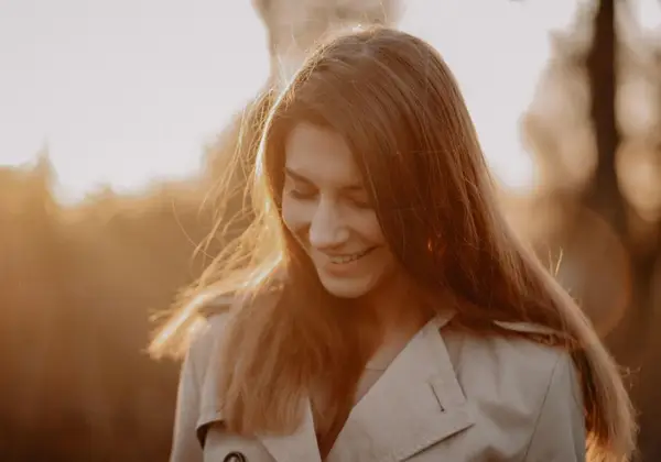 A woman smiling gently in golden evening light