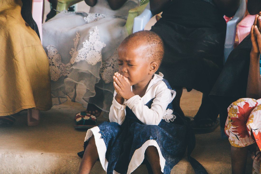 A child with hands folded in prayer