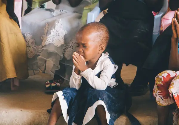A child with hands folded in prayer