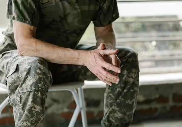 A veteran's weathered, clasped hands resting quietly