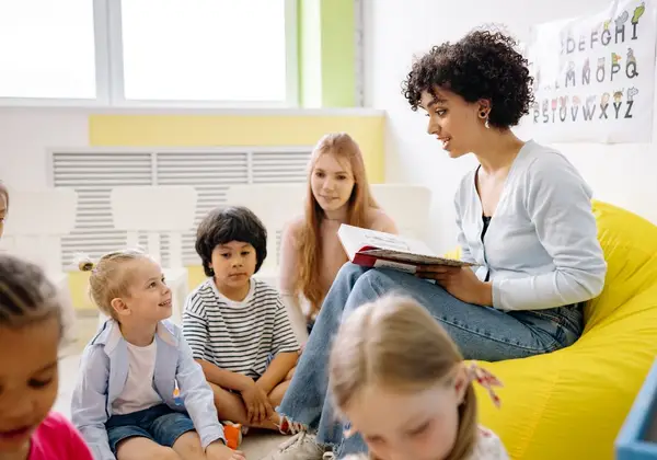 A children’s ministry leader reading a storybook to a circle of preschoolers