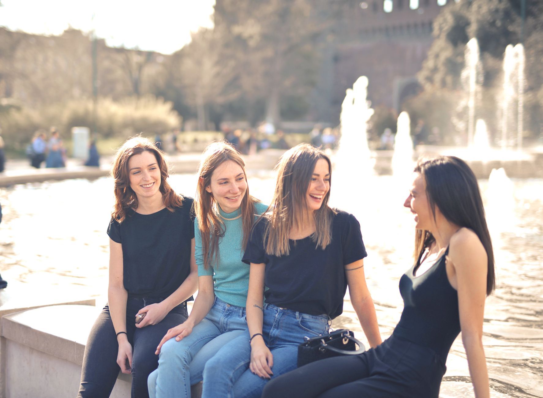 Friends laughing together by a fountain