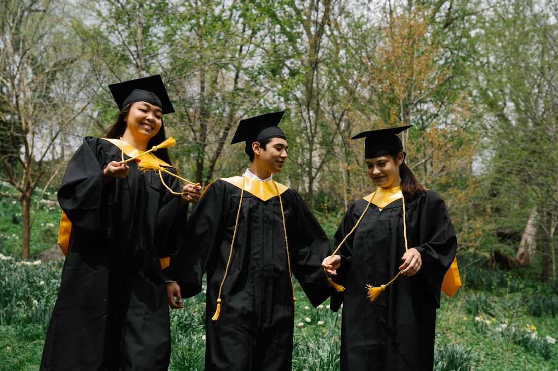 Three graduates smiling with their tassels