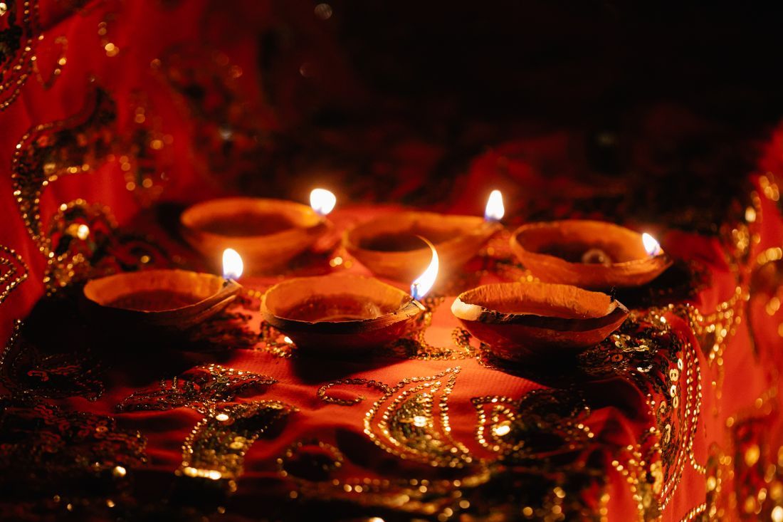 Lit diya oil lamps glowing in the dark