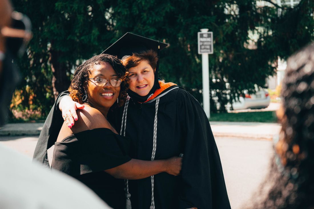 A graduate embracing a mentor with gratitude