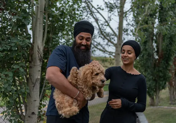 A young couple smiling together with their puppy