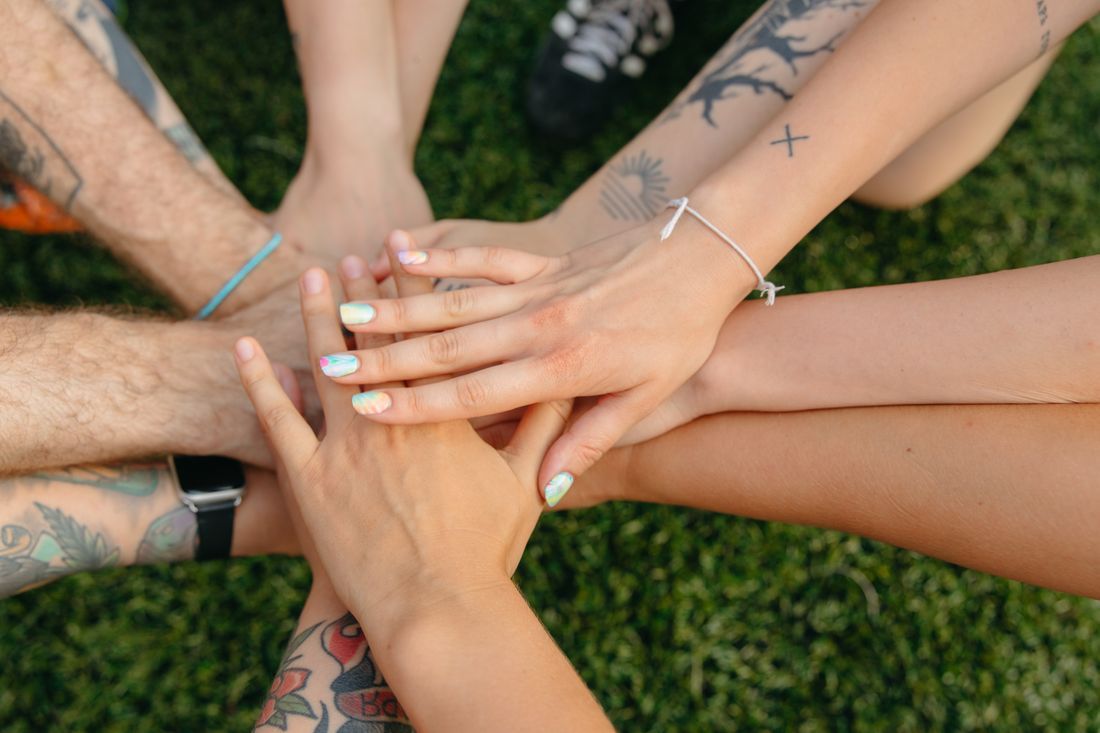 Friends placing their hands together in solidarity