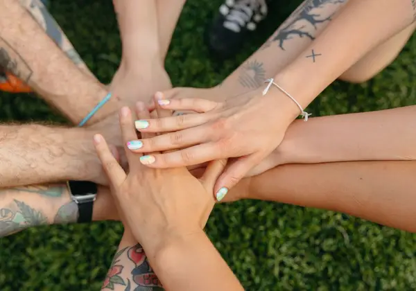 Friends placing their hands together in solidarity