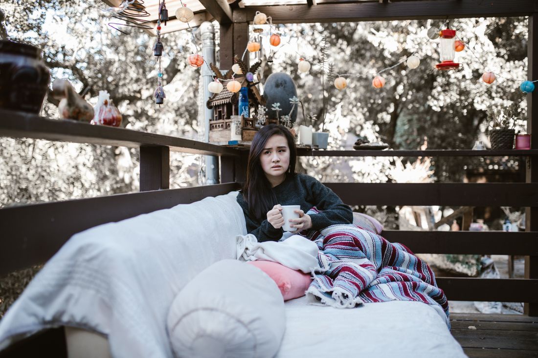 A young woman with a warm mug, resting outdoors