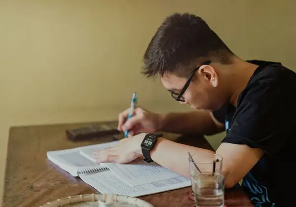 A student focused on his notes at a quiet table