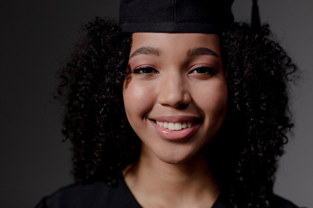 A smiling graduate in cap and gown
