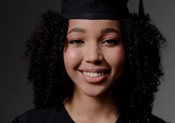 A smiling graduate in cap and gown