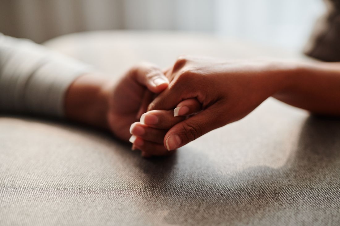 Two people holding hands in comfort