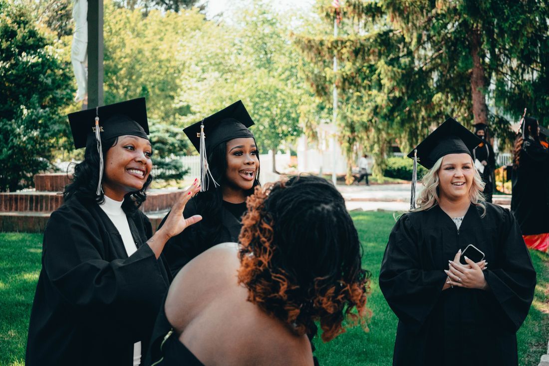 A diverse group of graduates celebrating in caps and gowns