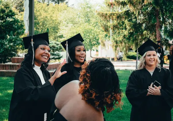 A diverse group of graduates celebrating in caps and gowns