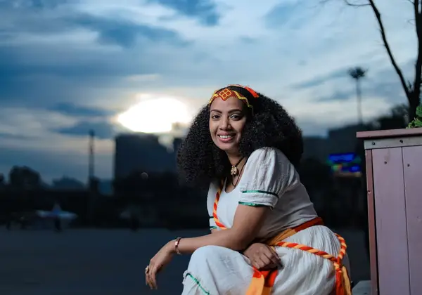 A smiling Ethiopian woman in traditional attire