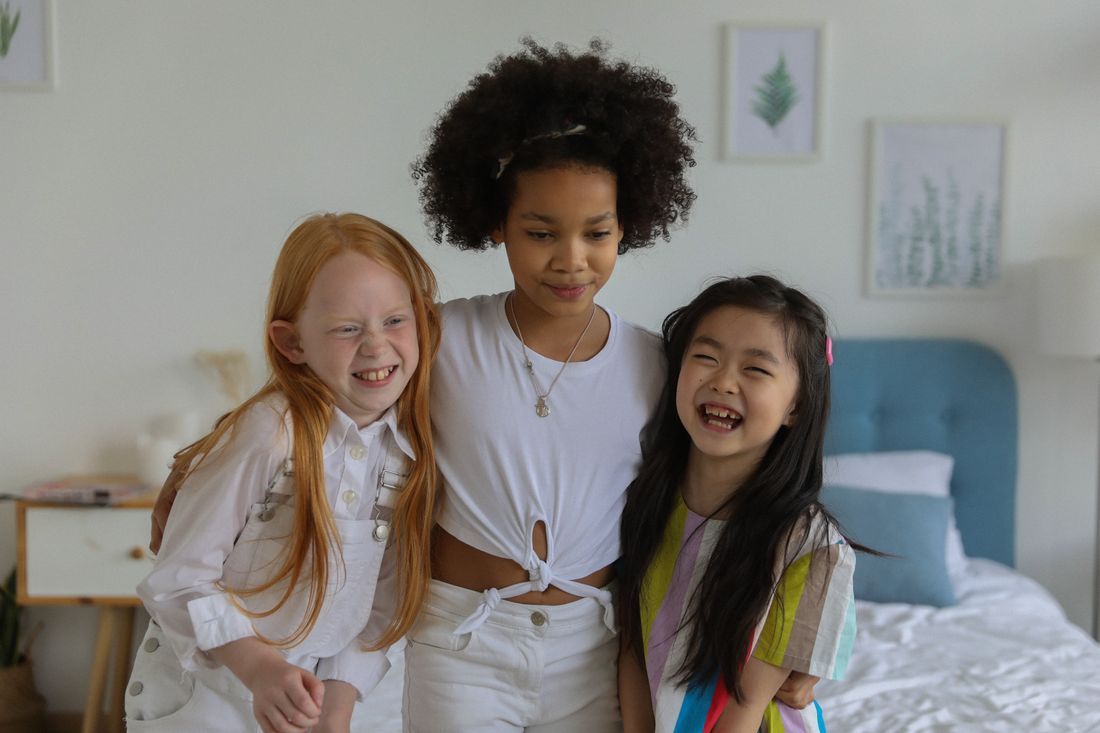 Three girls of different backgrounds hugging and smiling