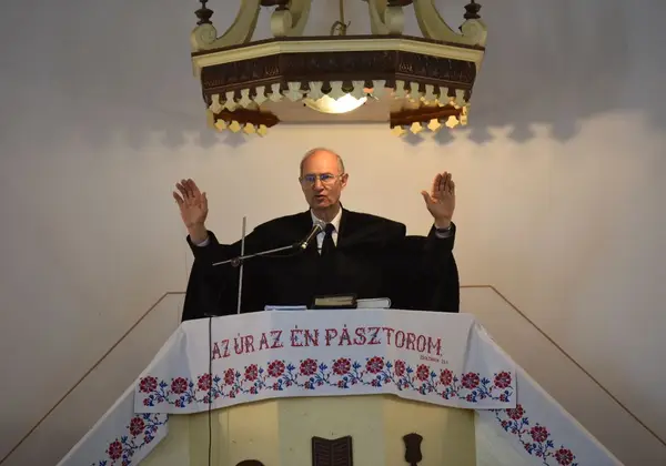 A pastor preaching from an ornate pulpit